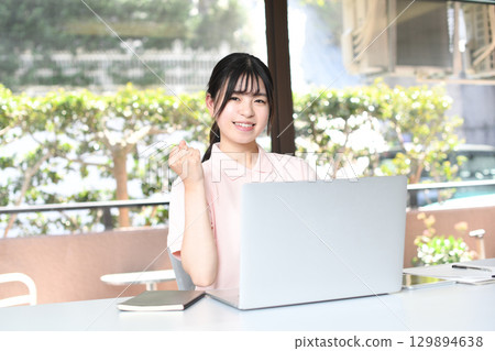 微笑的亞洲女性在電腦上做辦公室工作 129894638