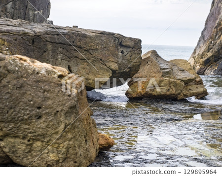 A view of huge rocks washed by the waves A view of huge rocks washed by the waves 129895964