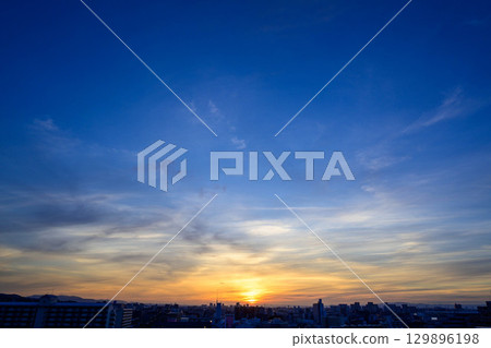 神戶的黎明時分，太陽從建築物的縫隙中升起，將整個區域籠罩在橙色之中，建築物也呈現出剪影的景象。 129896198