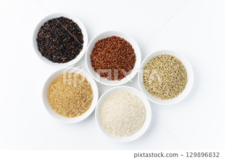 Various types of rice (white rice, germinated brown rice, black rice, red rice, green rice) arranged on a white background 129896832