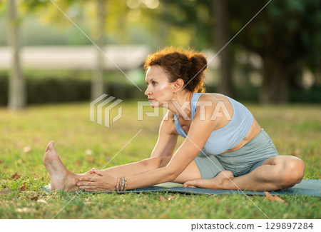 Adult woman doing stretching in park 129897284