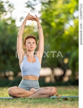 Adult woman doing yoga in lotus position Adult woman doing yoga in lotus position 129897522