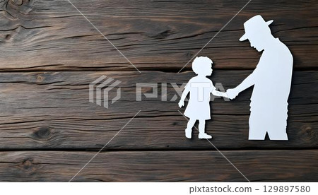 Father and daughter paper cutout holding hands, beautifully displayed on a wooden background, celebrating Father's Day 129897580