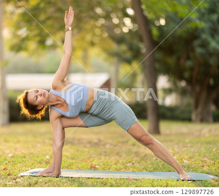 Adult woman doing yoga in park Adult woman doing yoga in park 129897726