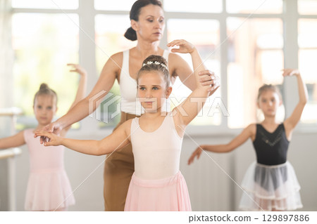 Lesson for little ballerinas - girls learn to dance ballet in choreographic class Lesson for little ballerinas - girls learn to dance ballet in choreographic class 129897886