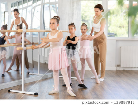 Ballet choreographer teaches little children to get into first position Ballet choreographer teaches little children to get into first position 129897915