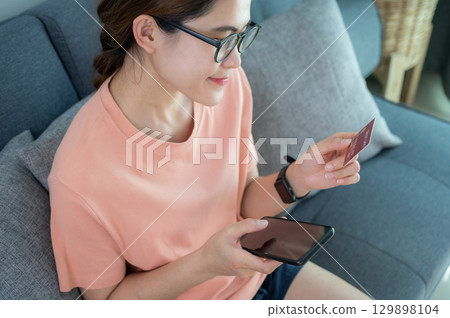 Asian woman while using credit card for shopping online on her mobile phone applications. Asian woman while using credit card for shopping online on her mobile phone applications. 129898104