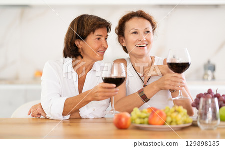 Party for girlfriends - women drinking wine and telling each other news Party for girlfriends - women drinking wine and telling each other news 129898185