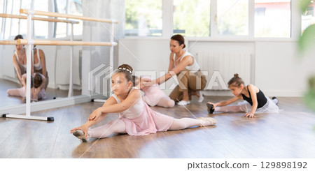 Group of girls doing splits in studio Group of girls doing splits in studio 129898192