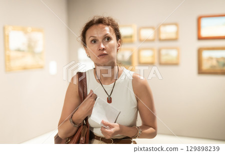 Intelligent woman visiting painting exhibition at museum Intelligent woman visiting painting exhibition at museum 129898239