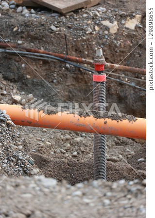 Pipe is sticking out of the ground in a muddy area Pipe is sticking out of the ground in a muddy area 129898655