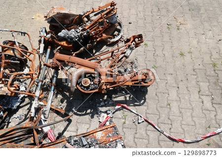 A pile of rusted motorcycle parts and a red and white rope 129898773