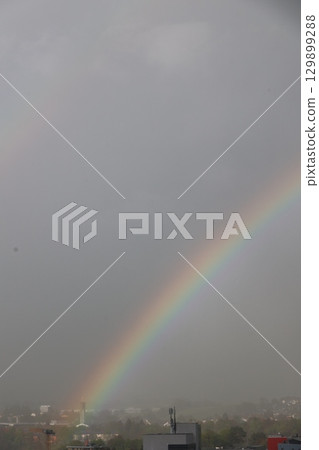 A rainbow is seen in the sky above a city A rainbow is seen in the sky above a city 129899288