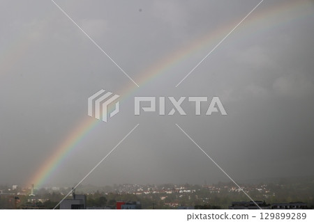A rainbow is seen in the sky above a city A rainbow is seen in the sky above a city 129899289