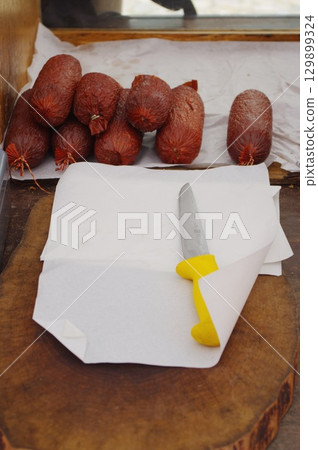 Knife is on a cutting board with a bunch of meat on top of it Knife is on a cutting board with a bunch of meat on top of it 129899324