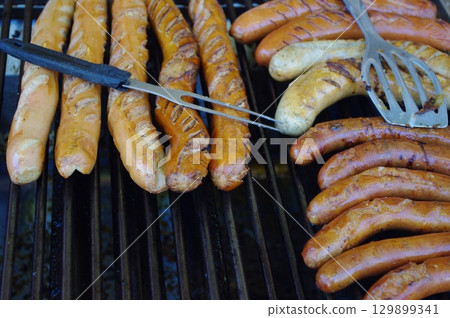 Grill with two sets of hot dogs on it 129899341
