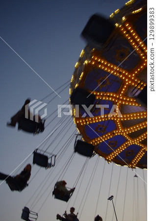 Carnival ride with people on it 129899383