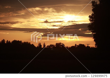 The sky is orange and the sun is setting 129899475