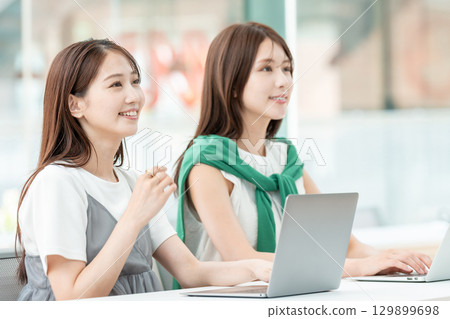 A university student operating a computer in a university classroom A university student operating a computer in a university classroom 129899698