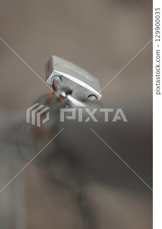 Silver lock is on a metal pole Silver lock is on a metal pole 129900035