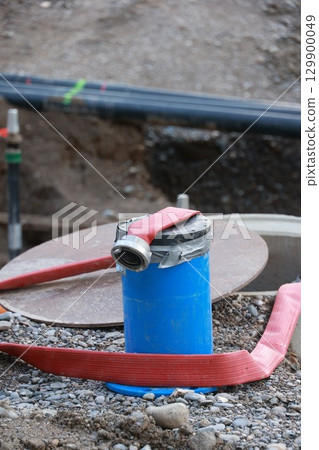 Blue pipe with a red hose on top of it Blue pipe with a red hose on top of it 129900049
