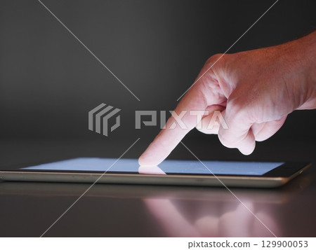 Hand pointing at a tablet screen Hand pointing at a tablet screen 129900053