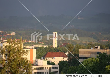 City view with a large clock tower in the middle 129900159