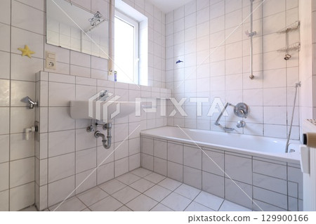 Bathroom with a white sink and a white bathtub Bathroom with a white sink and a white bathtub 129900166