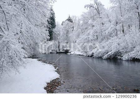 Snowy landscape with a river running through it 129900236