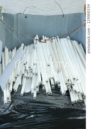 Pile of white light bulbs are in a trash can Pile of white light bulbs are in a trash can 129900334