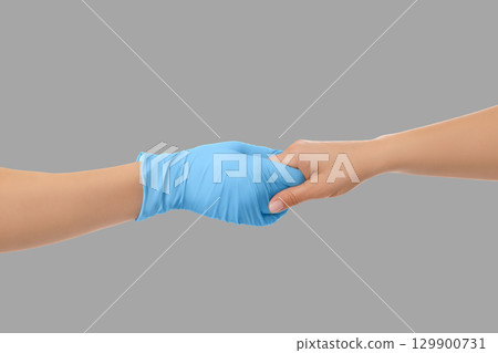 Medical staff offers reassurance through a gentle handhold 129900731