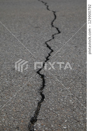 Crack in the road is shown in black and white 129900792