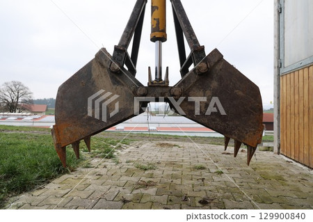 A large piece of equipment with a claw on the front 129900840
