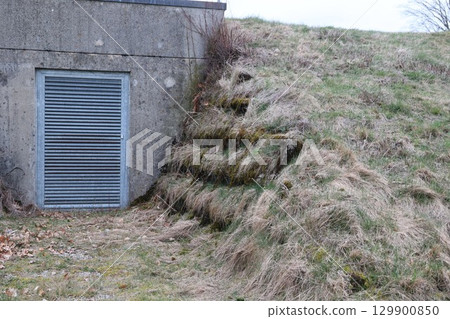 A concrete structure with a metal grate on the door A concrete structure with a metal grate on the door 129900850