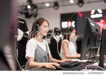 年輕女子在電競比賽中享受遊戲 年輕女子在電競比賽中享受遊戲 129900863