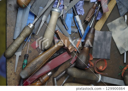 Table full of woodworking tools, including hammers, pliers, and knives Table full of woodworking tools, including hammers, pliers, and knives 129900864