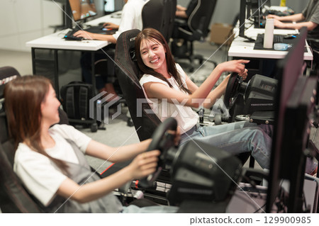 Young woman enjoying a racing game 129900985
