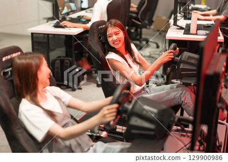 Young woman enjoying a racing game 129900986