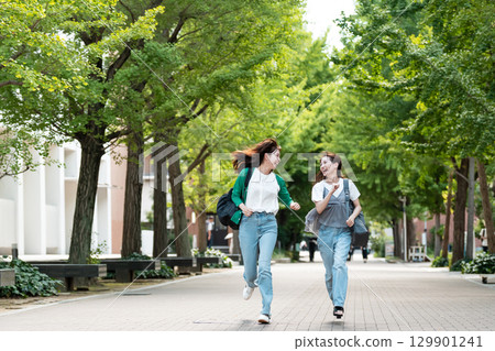 University campus female college student running 129901241