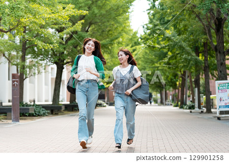 University campus female college student running 129901258