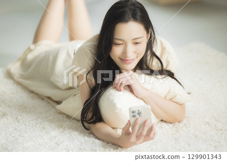 一個操作智能手機的年輕女子 129901343