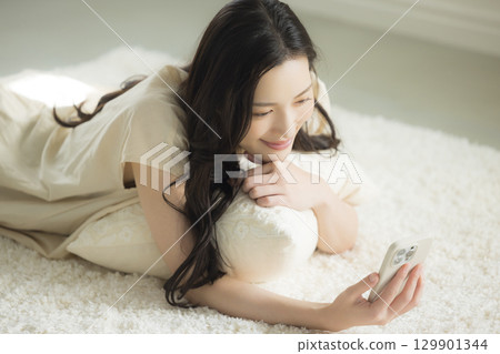 一個操作智能手機的年輕女子 一個操作智能手機的年輕女子 129901344
