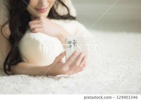 一個操作智能手機的年輕女子 一個操作智能手機的年輕女子 129901346