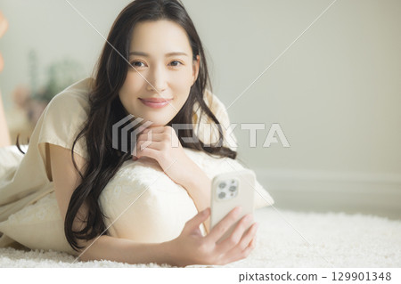 一個操作智能手機的年輕女子 129901348