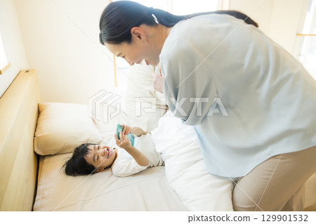 A child lying down and looking at a smartphone 129901532