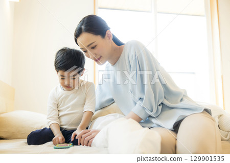 一個孩子躺著看智慧型手機 一個孩子躺著看智慧型手機 129901535