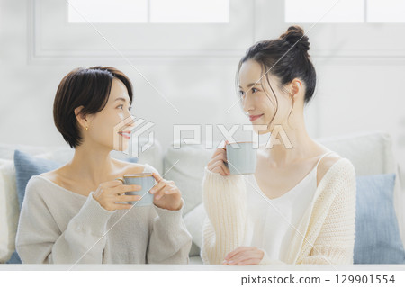 Woman drinking hot coffee in her room 129901554