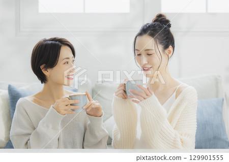 一個女人在她的房間裡喝熱咖啡 129901555