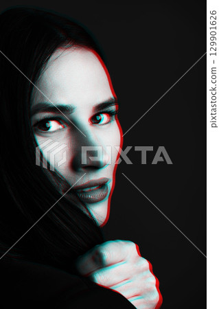 Portrait of beautiful woman holding her hair and looking to camera in RGB color split effect 129901626