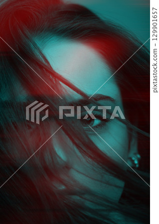 Beautiful woman with blue eyes cover her face with hair in RGB color effect style 129901657